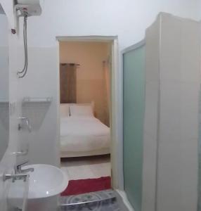 a bathroom with a sink and a bed in a room at Marrets International Villa in Accra