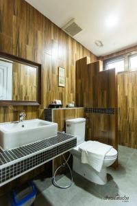 een badkamer met een wit toilet en een wastafel bij Huen San Fang hotel โรงแรมเฮือนแสนฝาง in Fang
