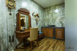 a bathroom with a wooden desk and a mirror at Huen San Fang hotel โรงแรมเฮือนแสนฝาง in Fang