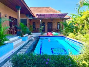 a swimming pool in front of a house at The Gradina Canggu in Canggu