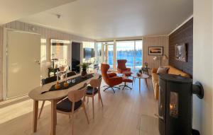 a living room with a table and chairs and a fireplace at Amazing Apartment In Sjusjen With Kitchen in Sjusjøen