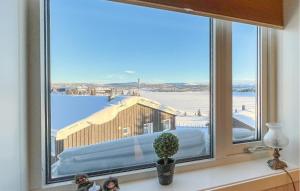 een raam met uitzicht op een gebouw in de sneeuw bij Amazing Apartment In Sjusjen With Kitchen in Sjusjøen