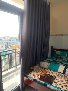 um quarto com uma cama e uma varanda com uma janela em NHÀ NGHỈ THANH XUÂN- Có cho thuê xe máy và xuất hóa đơn em Ấp Ðông An (1)
