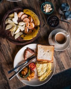 a table with a plate of breakfast food and a cup of coffee at Bardia Forest Resort in Bardia