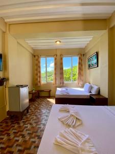 a hotel room with two beds and a window at Oceanfront Beach Resort in Siquijor