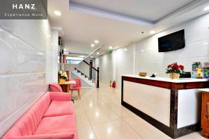 a lobby with a pink couch and a bar at HANZ Hoang Hoang Hotel Ben Thanh in Ho Chi Minh City