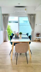 a dining table and chairs in a room with a window at TownHouse For Rent in Ban Thap Nang