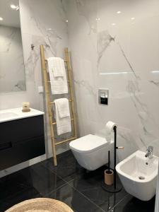 La salle de bains blanche est pourvue d'un lavabo et de toilettes. dans l'établissement Moodhu Villa - Cozy Apart w/ Amazing Terrace, à Leiria