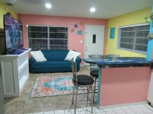 a living room with a blue couch and a kitchen at cozy 1drm beach place Treasure Island in St. Pete Beach
