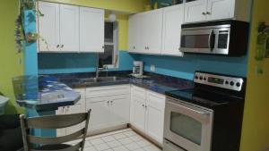 a kitchen with white cabinets and a sink and a stove at cozy 1drm beach place Treasure Island in St. Pete Beach