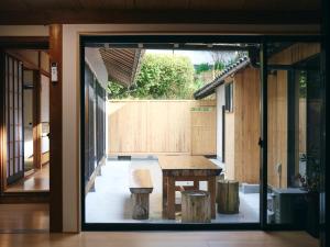 un patio con una mesa de madera y un banco en MIU HOUSE - Vacation STAY 30561v, en Izumo
