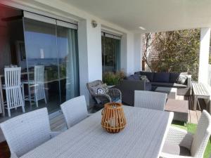 a table and chairs on a patio with a couch at Mountain & Sea Apartments in Kommetjie