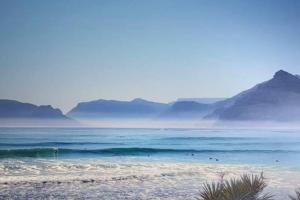 a view of a beach with mountains in the background at Mountain & Sea Apartments in Kommetjie