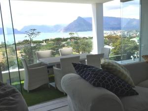 a living room with a couch and a table and chairs at Mountain & Sea Apartments in Kommetjie