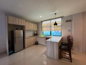 a kitchen with a refrigerator and a table and a chair at Studio at Samsuria Beach Resort in Kampung Sungai Ular