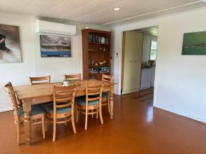 a dining room with a wooden table and chairs at Lake Holiday Home - Spa & Views in Mangakino