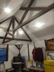 a room with a ceiling with wooden beams at La rose des Bois in Saint-Louis