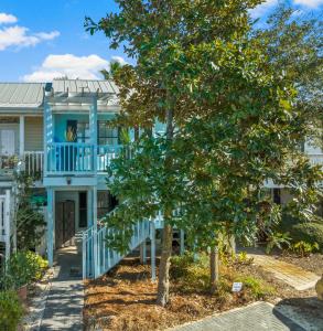 a blue house with a tree in front of it at Solitude on 30A - Seacrest Beach Townhouse with Beach Access - FREE BIKES in Rosemary Beach