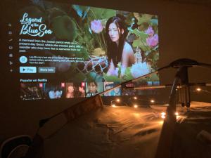 een tv-scherm met een foto van een vrouw erop bij Condo Glamping at Vinia in Manilla