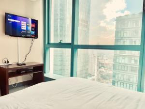 マニラにあるThompson Suites - 2-beds, One Uptown Residences, 30F - XBOX & Netflixのベッドルーム1室(ベッド1台、大きな窓付)