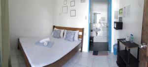 Habitación pequeña con cama y baño. en Hashtag Tourist Inn en San Vicente