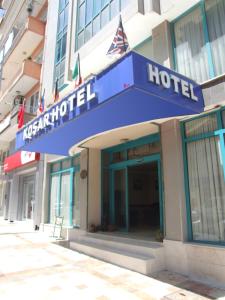 a hotel with a blue sign on a building at Kosar Hotel in Denizli