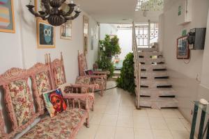 a room with a bunch of chairs and a staircase at Marias House - Magnifique Hotels in Santa Marta