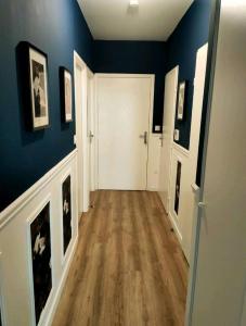 un pasillo con paredes azules y una puerta blanca en Superbe appartement en Gagny