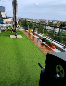 Habitación con vistas a un balcón con césped verde. en Superbe appartement en Gagny