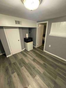 una sala de estar vacía con suelo de madera dura en Cozy and affordable suite (near Rutgers, smartTV), en New Brunswick