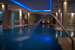ein Pool mit Wasserrutsche in einem Hotelzimmer in der Unterkunft Hotel Uthgra Sasso in Mar del Plata