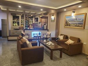 a living room with couches and a table and a kitchen at Tashi Pal Hotel Pvt. Ltd in Kathmandu