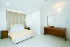 a bedroom with a bed and a mirror in it at Mersing Hotel in Mersing