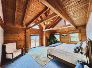 a bedroom with a large bed in a room with wooden walls at Misty Mountains Lodge in Ronceverte