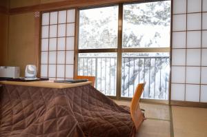 an office with a desk and a chair and windows at Ikoisanso in Karuizawa