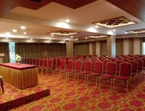 a large room with red chairs and tables in it at MANDARIN SKY in Kannur