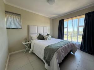a bedroom with a large bed and a window at The Palms Unit 5 in Kimberley
