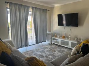 a living room with a couch and a flat screen tv at The Palms Unit 5 in Kimberley