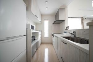 TsukisappuにあるTHE LUNA LOUNGEの白いキャビネット、シンク、窓付きのキッチン +154枚の写真