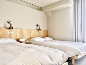 two beds sitting next to each other in a bedroom at 东京上野秋叶原超豪华双卧套房Ydob 最大8人上野公园3分钟 地铁1分钟位置绝佳超级繁华免费wifi Dyson吹风机 in Tokyo