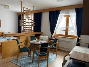 una habitación con mesa y sillas y un dormitorio en Samoobslužný hotel Vydra en Srní