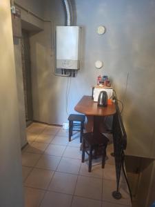 a room with a table with a microwave and a tv at Старий Дворик,кімнати біля жд вокзалу in Lviv