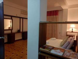2 foto di una camera d'albergo con letto e specchio di Tenshin Residance. a Kandy