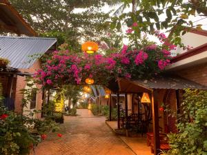 un callejón con flores rosas colgando de un edificio en AND Resort, en Phu Quoc