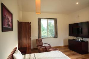 una camera da letto con un letto e una TV a schermo piatto di The HighGarden Resort a Udaipur