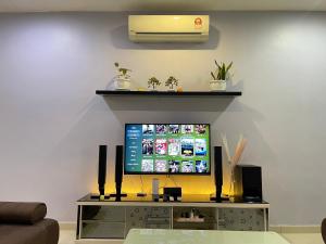 una TV a schermo piatto seduta su un centro di intrattenimento di JJ&KK Homestay a Simpang