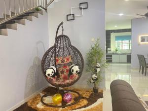 un dondolo in vimini in un soggiorno con scala di JJ&KK Homestay a Simpang