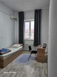a bedroom with a bed and a chair and a desk at Kamkor in Atyrau