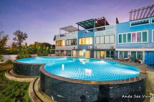 ein Haus mit zwei Pools davor in der Unterkunft Anda Sea View Pranburi in Ban Pak Nam Pran