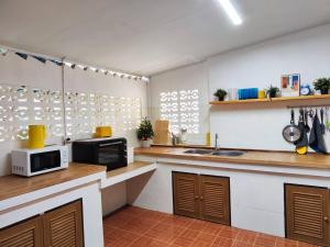 a kitchen with a sink and a microwave at Coral Cottage Beach House @ Phang Nga in Thai Muang